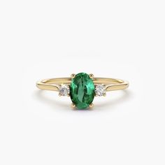 This stunning 14k oval shape emerald and diamond 3 stone ring is the perfect accessory for any occasion. The deep green emerald stone is nestled between two dazzling diamonds, creating a stunning contrast that catches the eye. The 14k gold band adds a touch of sophistication and elegance, making this ring a timeless piece that will never go out of style. With its classic design and high-quality materials, this ring is sure to become a treasured addition to any jewellery collection. Perfect for engagements, anniversaries, or any other special occasion, this ring is a true statement piece that will impress anyone who sees it.Details	Made to Order	Gold Kt: 14K (also available in 14k)	Available Gold Color: Rose Gold, Yellow Gold, White Gold	Oval Emerald: 1 pc 6x4MM	Roun Diamond: 2 pcs 2.0 MM	N Unconventional Engagement Rings, Dream Engagement Ring, 3 Stone Ring, Sapphire Engagement Rings, Cute Engagement Rings, Silver Diamond Ring, Emerald Rings, 3 Stone Rings, Local Jewelry