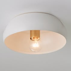 a light that is on the ceiling in a room with white walls and flooring