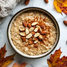 a bowl of oatmeal with nuts and maple leaves