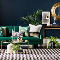 a living room with green couches and plants on the table in front of it