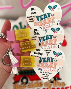 two heart shaped keychains with words on them, one saying merry very merry and the other saying happy new year