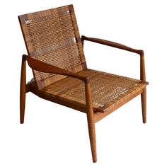 a chair made out of wood and wicker with a wooden arm rest on top of it