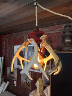 an antler lamp hanging from the ceiling in a cabin