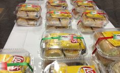 several plastic containers filled with food sitting on top of a white tablecloth covered table