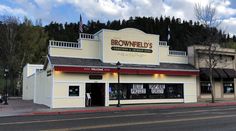 the brownfield's restaurant is located on the corner of an empty street with trees in the background