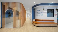 an office lobby with curved wooden slats on the wall and wood flooring along the walls