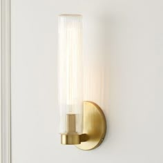 a light that is on the wall next to a white door with a glass tube