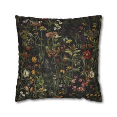 a black pillow with flowers and butterflies on it