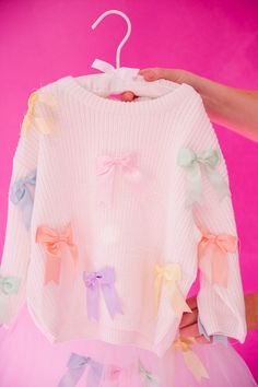 Hop into spring with our MINI KIDS PASTEL BOWS SWEATER! This cozy white waffle sweater features adorable pastel bows on the pullover, perfect for Easter or any day. Get your little one ready to bloom in style! This is a made-to-order item. All customized orders are currently shipping within 14 business days. To receive item quicker, expedited shipping is available at checkout. Long Sleeve Sweater With Bow For Spring, Spring Long Sleeve Sweater With Bow, Playful White Sweater For Spring, Pastel Bows, Waffle Sweater, Bow Sweater, Little One, In Style, Pastel