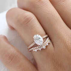 a woman's hand with a diamond ring on it and two wedding bands around the band