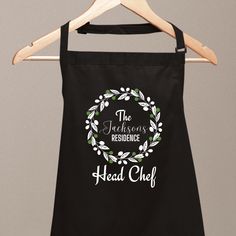 a black apron with the words head chef on it hanging from a wooden hanger