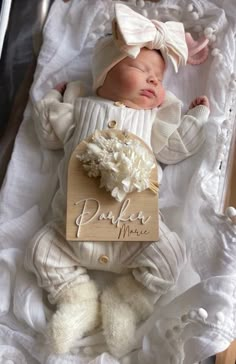 a baby is laying down in a box with a name tag on it's chest