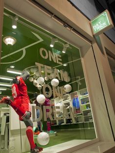 a window display with mannequins and soccer balls