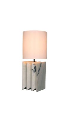 a lamp that is sitting on top of a white wall mounted fixture with a marble base