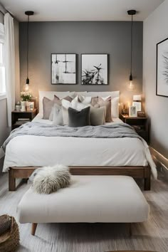 a bedroom with gray walls, white bedding and two framed pictures on the wall