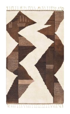 a brown and white rug with fringes on the bottom, in an abstract pattern