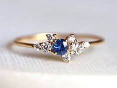 a blue and white diamond ring sitting on top of a table