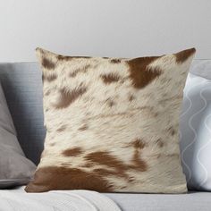 a brown and white spotted animal print pillow on a couch