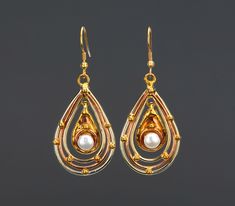 An irradiating piece of jewelry, this earring has: A triple layer teardrop frame with alternating metal/color (brass - copper -brass). A copper base teardrop pendant with a pearl (7 mm) A gold toned brass earwire.  Total length: 62 mm teardrop pendant:  38 x 26 mm center pendant: 20 x 13 mm Pearls : 7 mm If you have questions, please send me a message. Teardrop Pearl Earrings With Metal Ear Wire, Teardrop Metal Pearl Earrings, Teardrop Pearl Earrings In Metal, Metal Teardrop Earrings With Pearl Drop, Metal Teardrop Pearl Drop Earrings, Gold Teardrop Pearl Drop Chandelier Earrings, Metal Teardrop Chandelier Earrings With Pearl Drop, Teardrop Pearl Drop Chandelier Earrings As Gift, Pierced Teardrop Pearl Earrings