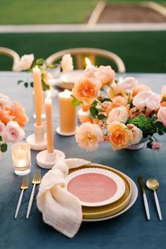 the table is set with flowers and candles