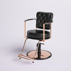 a black chair with a gold frame and foot rest in front of a white background