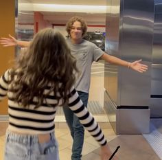 two people are standing in front of an elevator