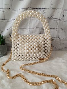 Elegance meets opulence in this beaded pearl bag. Elevate your style with a touch of sophistication and luxury. Dimension: Width: 16cm Height: 12cm Depth: 8cm The bag comes with a detachable handle which measures 110cm. Feel free to contact me for any questions. Chic Pearl Party Bags, Chic Pearl Shoulder Bag For Party, Chic Pearl Bags For Parties, Pearl Embellished Bags For Party, Cream Pearl Shoulder Bag For Party, Party Bags With Pearl Chain, Beige Pearl Party Shoulder Bag, Embellished Pearl Bags For Party, Party Pearl Embellished Bags