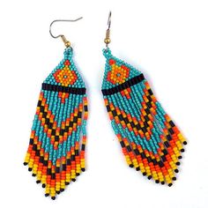 two pairs of beaded earrings are shown on a white surface, one is orange and the other is blue