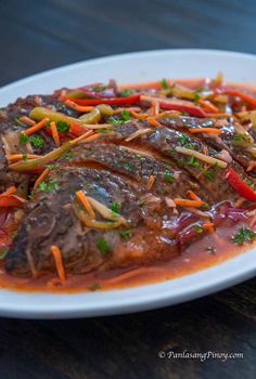 a white plate topped with meat covered in sauce