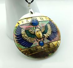 Mother of pearl sacred Egyptian Scarab necklace painted directly on mother of pearl for a 3D perspective Ancient Egypt's sacred blue and gold color (gold leaf) with hieroglyphic inscriptions Protection charm Absolutely jaw-dropping and one of a kind Entirely hand painted and hand made, signed Atlantic mother of pearl, thick shell Mother of pearl back D.6cm Jewellery cord full length approx. 60cm, adjustable Lobster claw clasp Abalone Shell Inlay Jewelry For Gifts, Gold Abalone Shell Pendant Jewelry, Gold Abalone Shell Necklace In Unique Style, Handmade Gold Jewelry With Abalone Shell, Unique Gold Abalone Shell Necklaces, Unique Gold Abalone Shell Necklace, Unique Gold Necklace With Abalone Shell, Unique Gold Jewelry With Abalone Shell, Gold Abalone Shell Round Jewelry