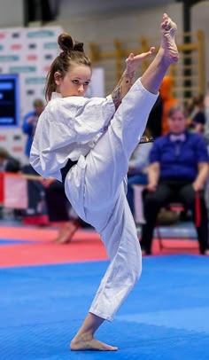 a woman is doing karate on a blue mat