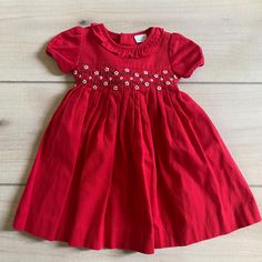 Edgehill Collection Red Smocked Floral Dress. Size 9 months. Buttons in the back with tie. Excellent used con Red Fitted Smocked Dress For Spring, Red Smocked Bodice Dress For Holiday, Fitted Red Smocked Dress For Spring, Short Sleeve Dresses With Smocked Back For Playtime, Red Fitted Dress With Smocked Bodice, Red Fitted Dress With Smocked Back, Holiday Dresses With Smocked Back, Cotton Dresses With Smocked Cuffs For Playtime, Fitted Red Smocked Dress