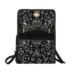 a black and white handbag with skulls on the front, stars and moon designs