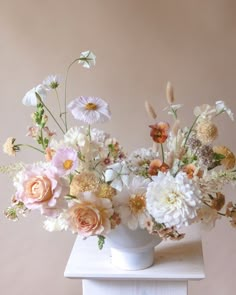 a white vase filled with lots of flowers