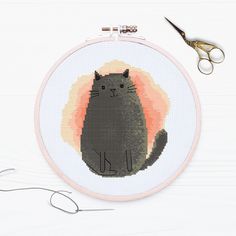 a cross - stitch kit with scissors and a black cat on it, sitting in front of a white background