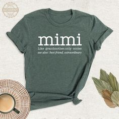 a t - shirt with the words mimi on it next to a cup of coffee