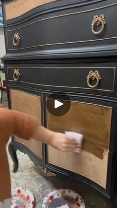 a person is cleaning an old dresser with a cloth