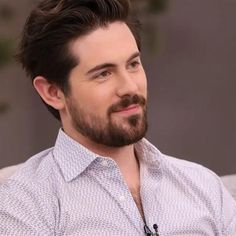 a man with a beard sitting in a chair