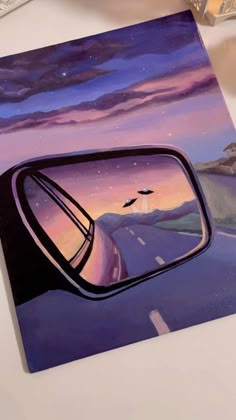 a car's side view mirror reflecting the night sky and birds flying in the distance