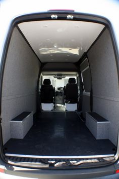 the back end of a van with its doors open and seats folded down in front