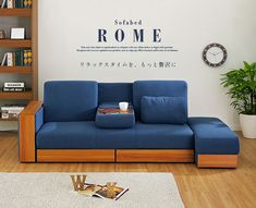 a blue couch sitting on top of a hard wood floor next to a book shelf