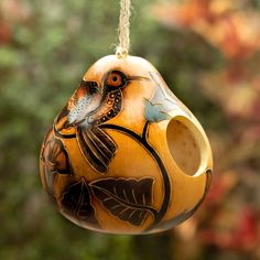 a ceramic bird feeder hanging from a tree