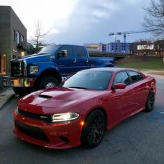 two red dodge trucks parked next to each other