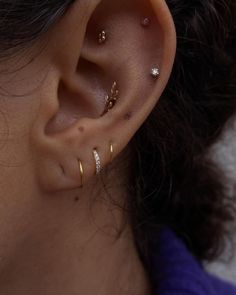 a close up of a person's ear with three different types of piercings