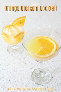 two glasses filled with orange blossom cocktail on top of a white counter next to each other