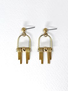 These Art Deco inspired earrings feature sleek, modern design elements, highlighting the radiant golden brass. Each earring boasts a distinctive arched geometric shape inspired by the Art Deco style, lending a sense of elegance and sophistication.  The stepped cut brass fringe creates movement and shine and adds to the uniqueness and contemporary design.  Their minimalist yet bold design embodies a harmonious balance between simplicity and intricacy, making them a versatile accessory suitable for both formal occasions and everyday wear. Each earring is finished with a brass ball stud with stainless steel post. Approximate measurements- 4.5 long 1.5cms wide These earrings are available in three variations- -Black Agate semi precious stone -Green Agate semi precious stone  -All Brass Please Modern Gold-tone Drop Linear Earrings, Modern Gold-tone Dangle Linear Earrings, Modern Gold Dangle Chandelier Earrings, Modern Gold Chandelier Earrings With Ear Wire, Modern Gold Metal Chandelier Earrings, Modern Gold-tone Linear Earrings, Modern Gold-tone Linear Drop Earrings, Modern Yellow Gold Linear Earrings, Modern Gold-tone Brass Earrings