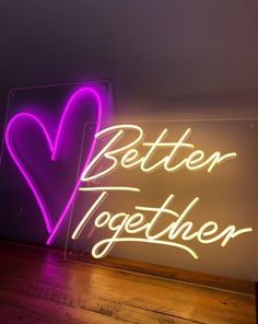 a neon sign that says better together with a heart in the middle and words below it