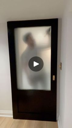 a man is standing in front of a glass door with the reflection of him on it