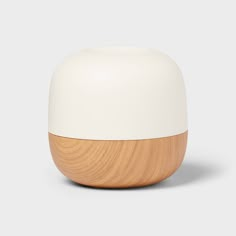 a white and wood vase sitting on top of a table