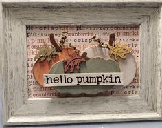 a white frame with some pumpkins and leaves on it